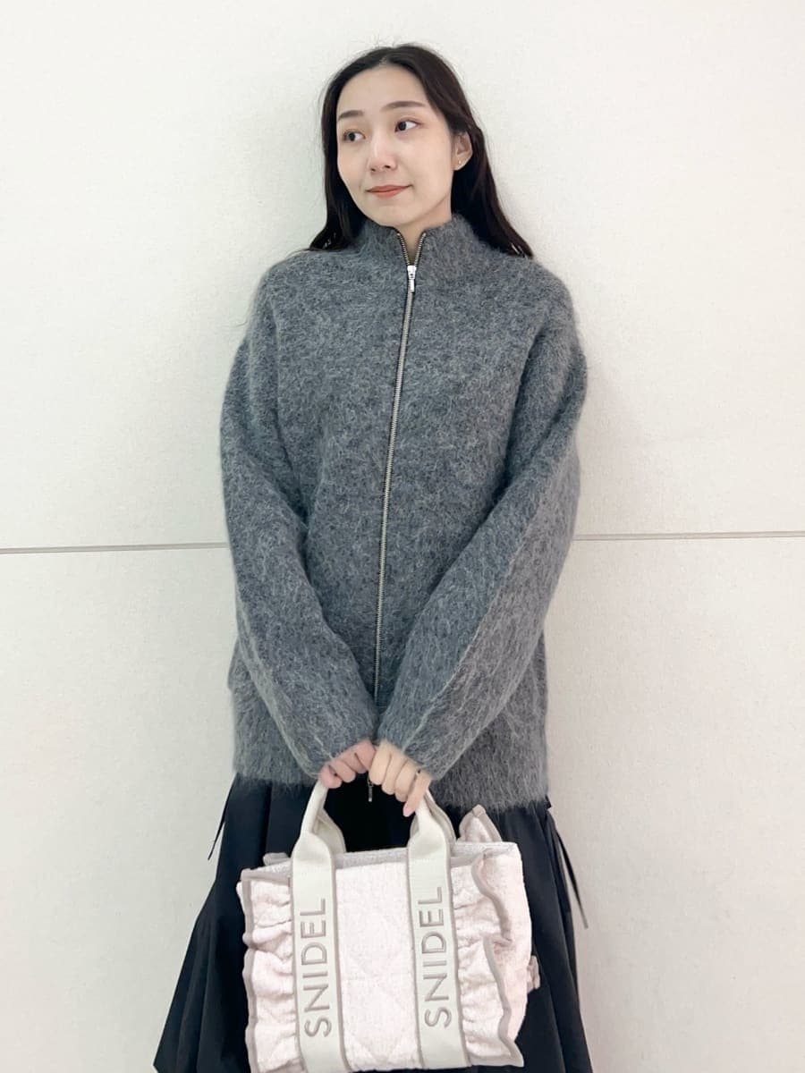 グレー系のブルゾン、ブラック系のスカート、ピンク系のハンドバッグを着用したレディースの秋コーディネートの5枚目の写真