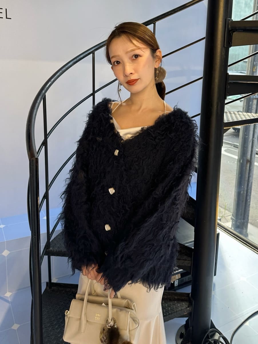 ホワイト系のワンピース、ブルー系のカーディガン/ボレロ、ホワイト系のボストンバッグを着用したレディースの秋コーディネートの2枚目の写真