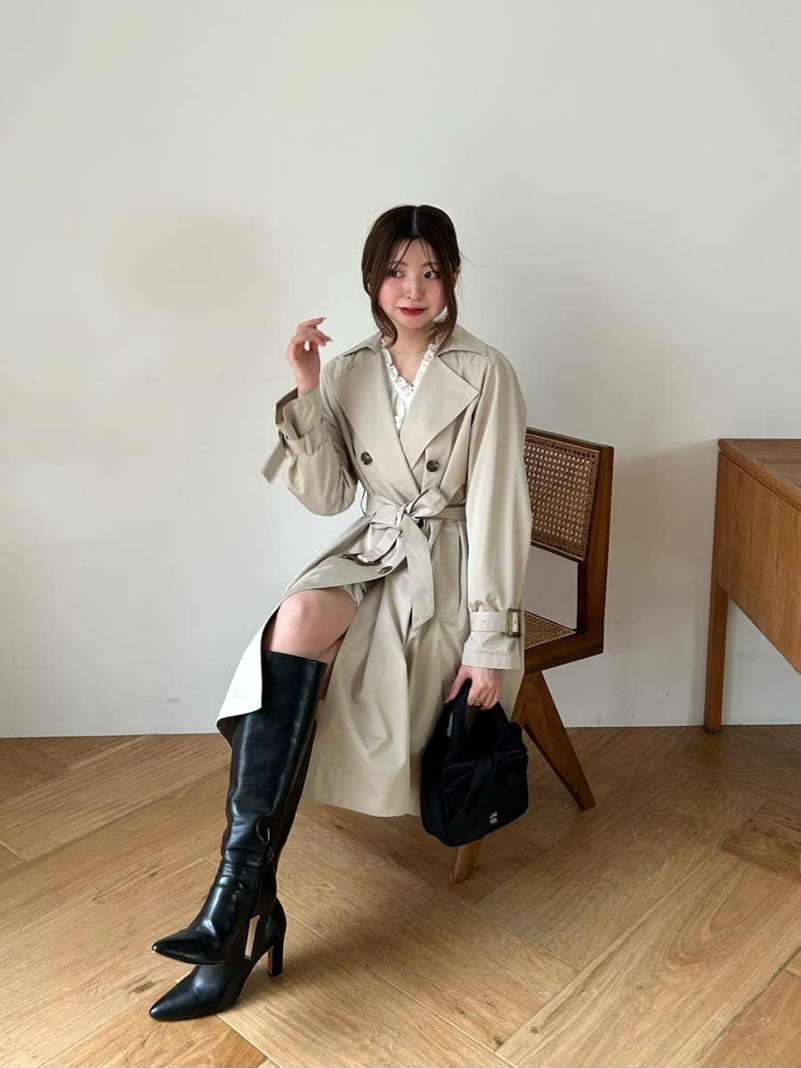 ブラック系のブーツ、ホワイト系のその他トップス、ベージュ系のトレンチコートを着用したレディースの春コーディネートの8枚目の写真