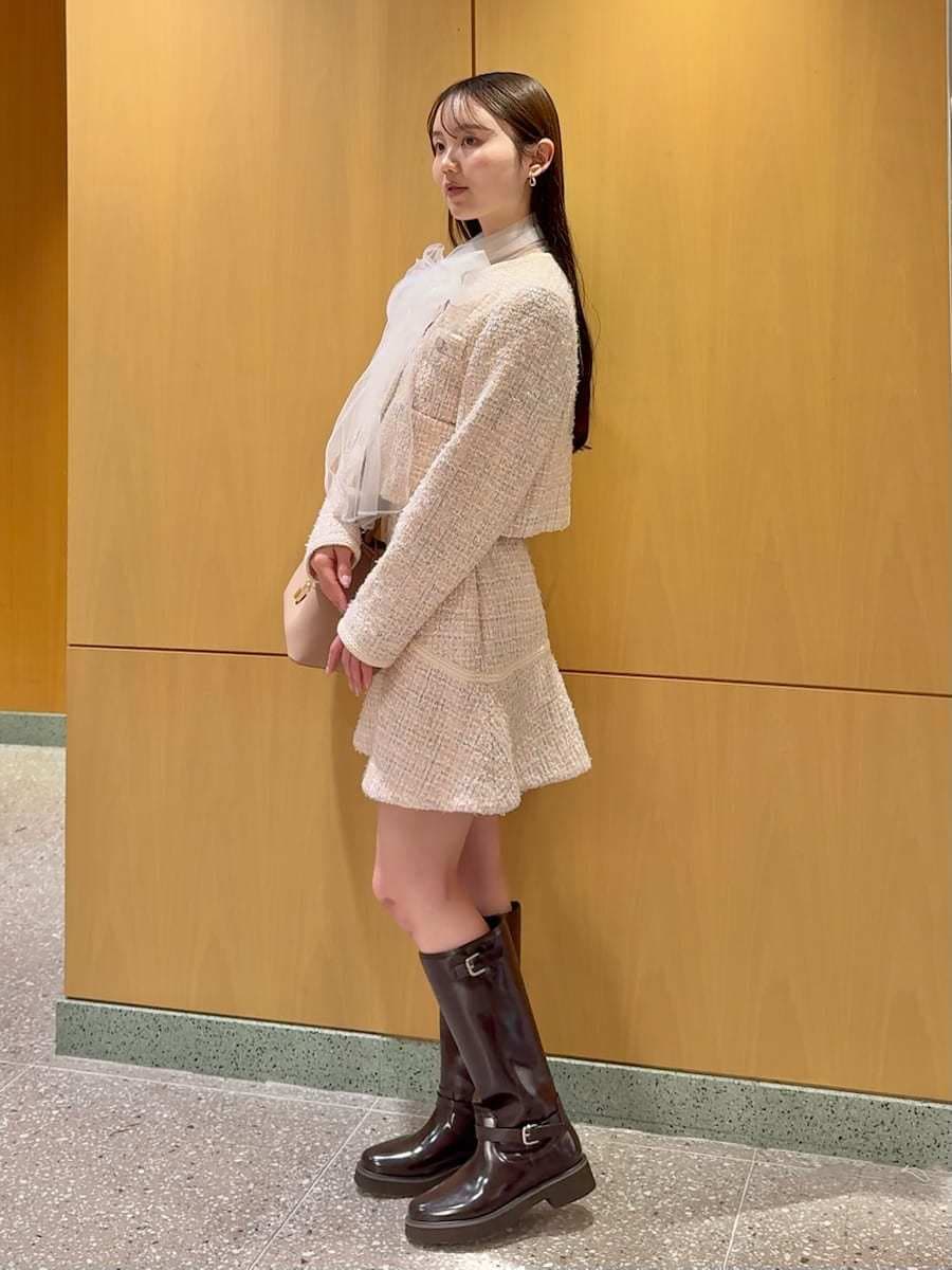 ピンク系のショルダーバッグ、ブラウン系のブーツ、ホワイト系のシャツ/ブラウスを着用したレディースの冬コーディネートの3枚目の写真