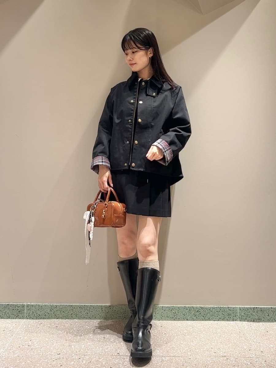 ブラック系のブルゾン、ブラック系のワンピース、ブラウン系のボストンバッグを着用したレディースの秋コーディネートの3枚目の写真