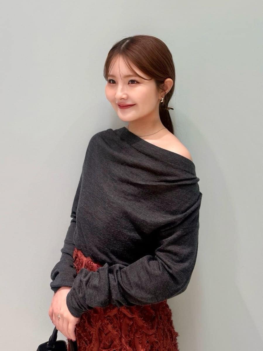 レッド系のブーツ、グレー系のチェスターコート、レッド系のスカートを着用したレディースの冬コーディネートの3枚目の写真