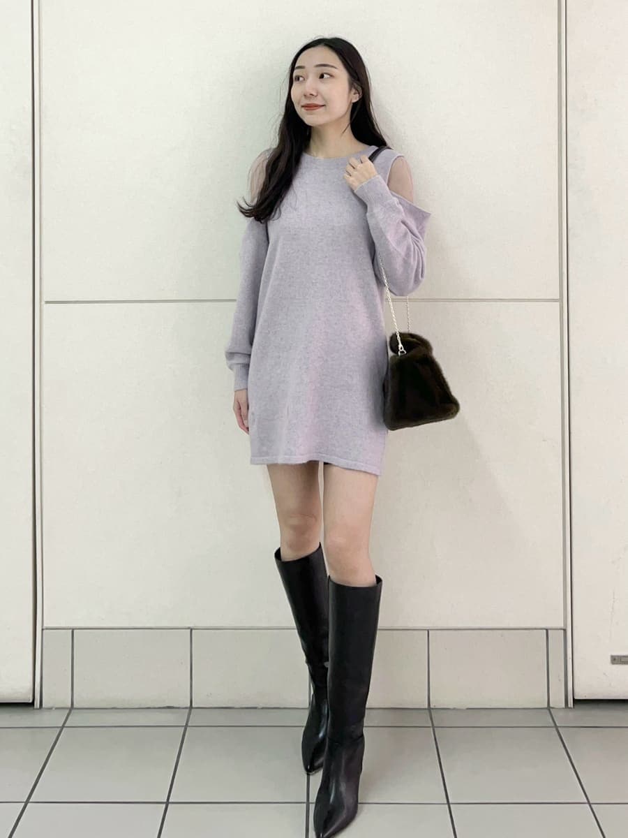 ブラック系のブーツ、パープル系のワンピース、ブラウン系のハンドバッグを着用したレディースの冬コーディネートの2枚目の写真