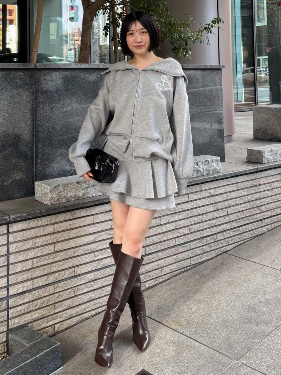 ブラウン系のブーツ、グレー系のパーカー、ブラック系のボストンバッグを着用したレディースの冬コーディネートの2枚目の写真