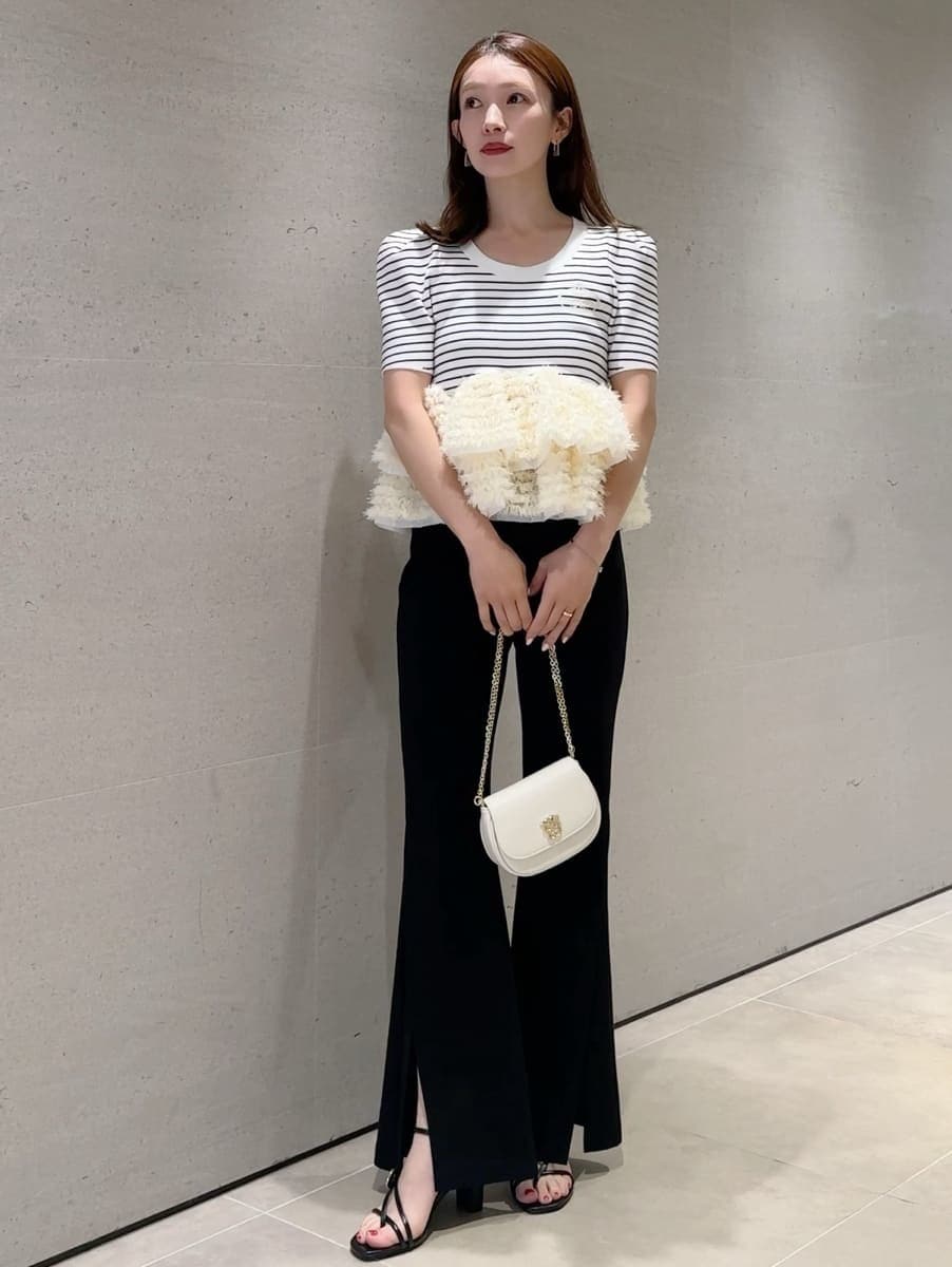 ブラック系のその他パンツ、その他のニット/セーター、ホワイト系のショルダーバッグを着用したレディースの春コーディネートの4枚目の写真