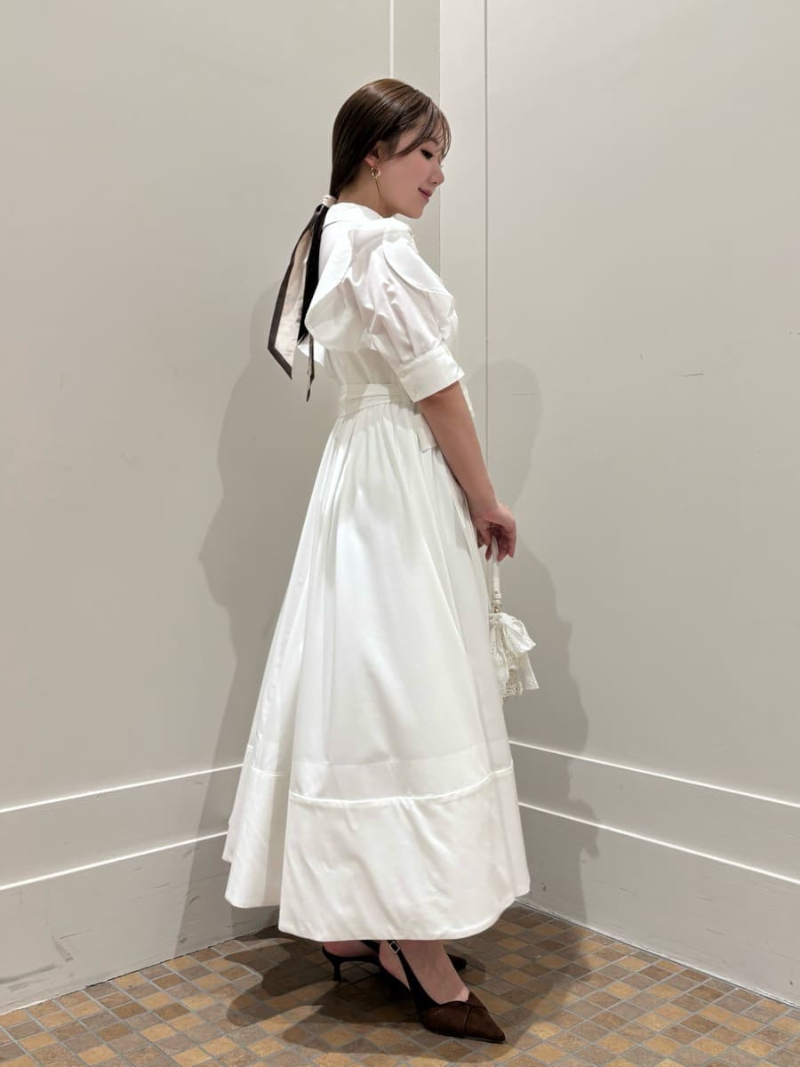 ブルー系のテーラードジャケット、ホワイト系のワンピース、ブラウン系のパンプスを着用したレディースの冬コーディネートの3枚目の写真