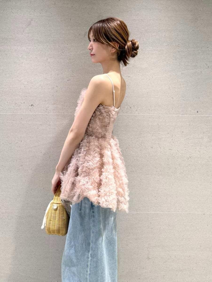 ホワイト系のかごバッグ、ブルー系のデニムパンツ、ブラウン系のサンダルを着用したレディースの夏コーディネートの4枚目の写真
