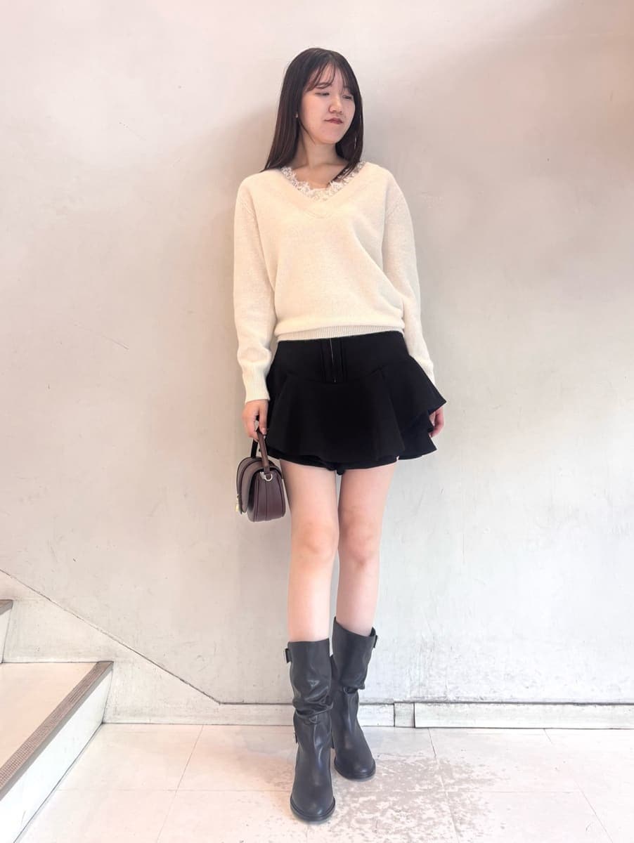 ブラウン系のハンドバッグ、ホワイト系のニット/セーター、ブラック系のその他パンツを着用したレディースの秋コーディネートの2枚目の写真