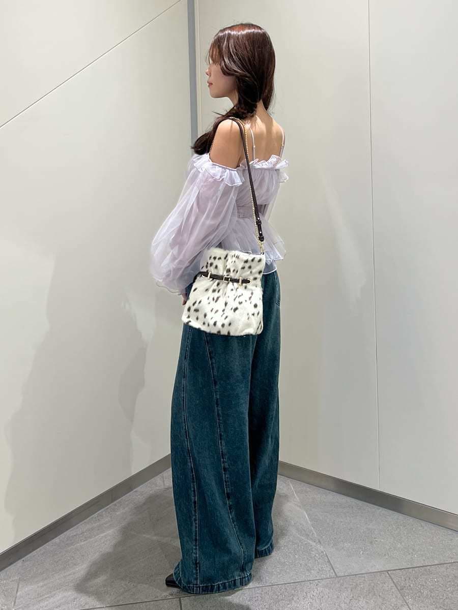 ブルー系のデニムパンツ、パープル系のシャツ/ブラウス、ブラウン系のパンプスを着用したレディースの秋コーディネートの2枚目の写真
