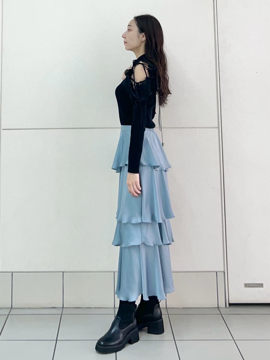 ブラック系のニット/セーター、ブルー系のスカート、ブルー系のショルダーバッグを着用したレディースの秋コーディネートの3枚目の写真