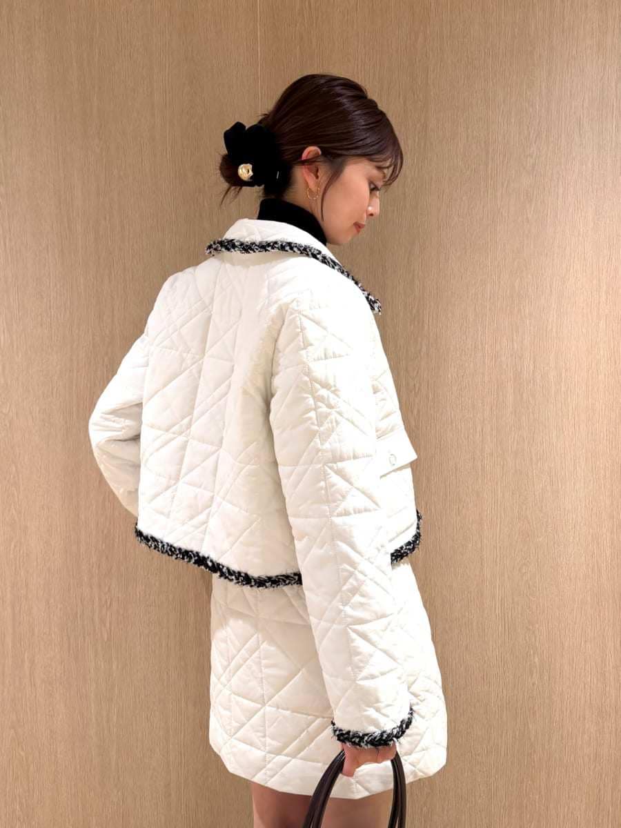 ホワイト系のテーラードジャケット、ホワイト系のスカート、ブラウン系のブーツを着用したレディースの秋コーディネートの3枚目の写真
