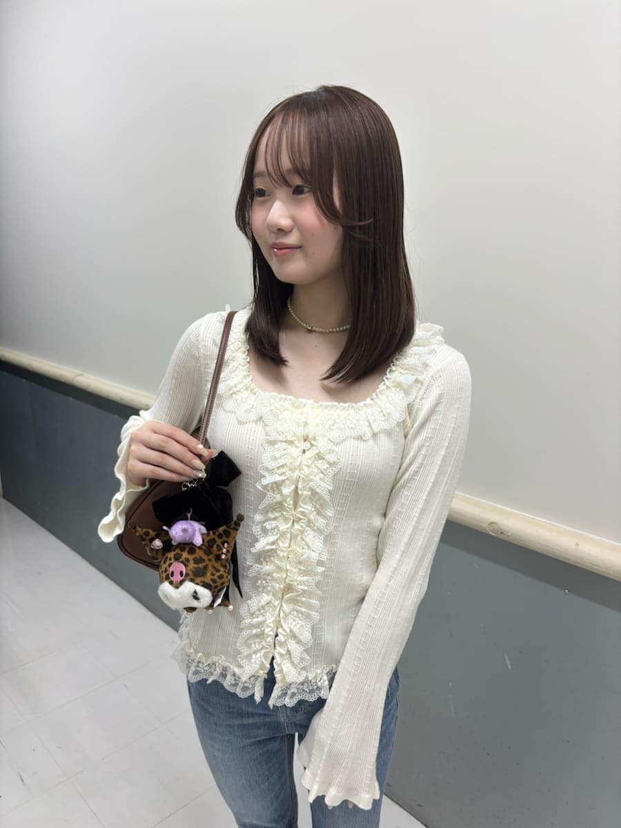 ホワイト系のニット/セーター、ブラウン系のサンダル、ブルー系のデニムパンツを着用したレディースの夏コーディネートの6枚目の写真