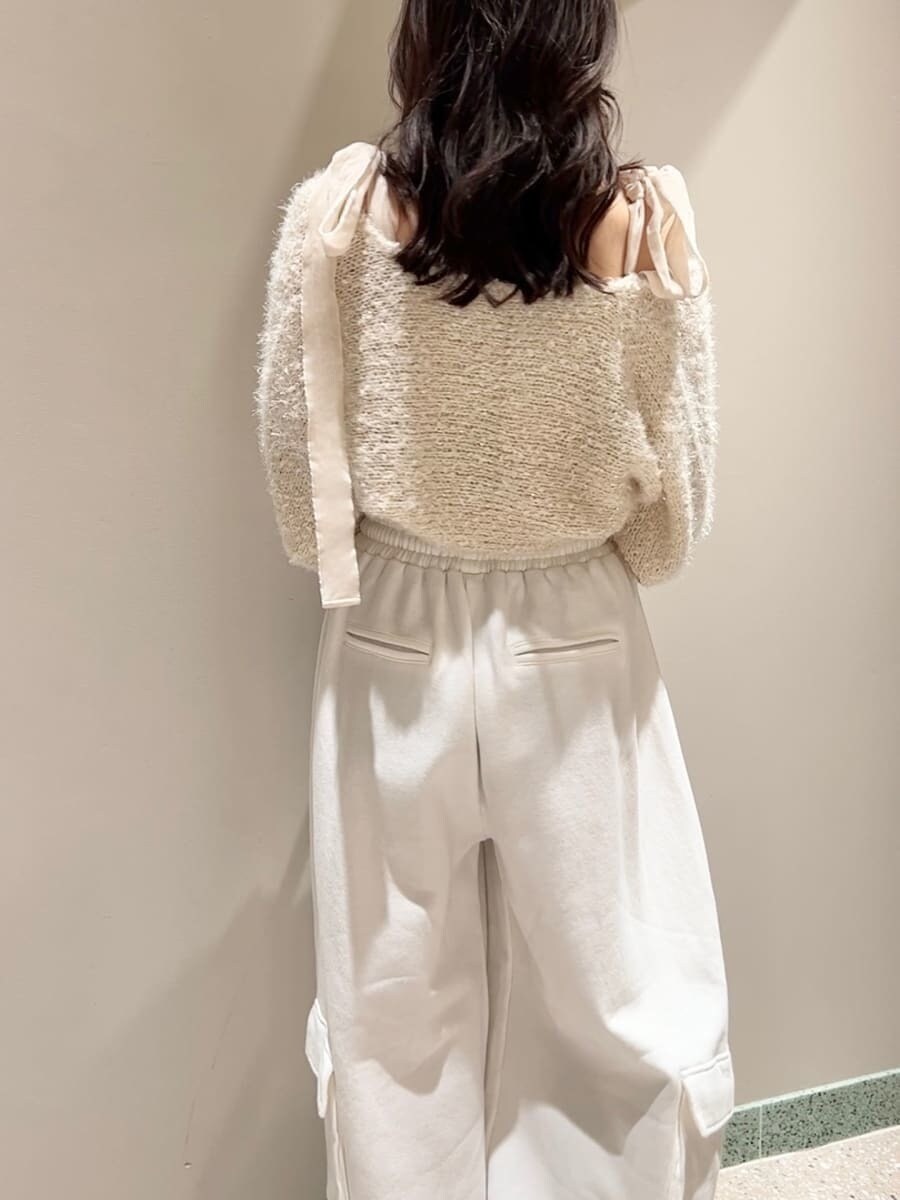 レッド系のブーツ、ホワイト系のニット/セーター、ホワイト系のスウェットパンツを着用したレディースの冬コーディネートの5枚目の写真