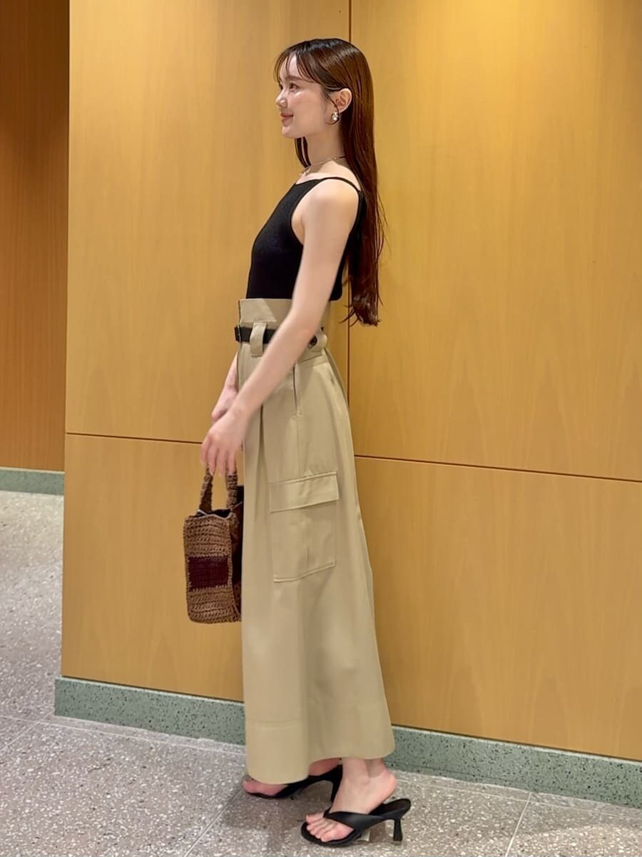 ベージュ系のスカート、ブラック系のニット/セーター、ブラウン系のトートバッグを着用したレディースの夏コーディネートの2枚目の写真