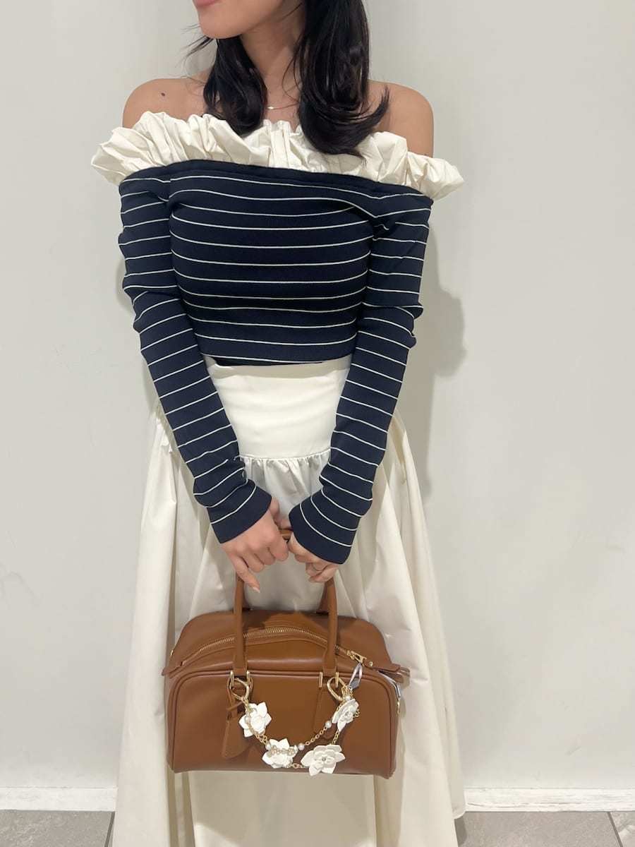 ブラウン系のブーツ、ホワイト系のスカート、その他のニット/セーターを着用したレディースの冬コーディネートの5枚目の写真