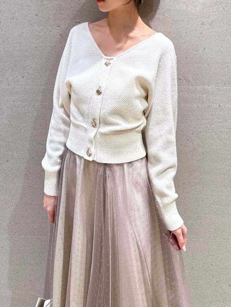 ブラック系のブーツ、ホワイト系のワンピース、グリーン系のチェスターコートを着用したレディースの秋コーディネートの6枚目の写真