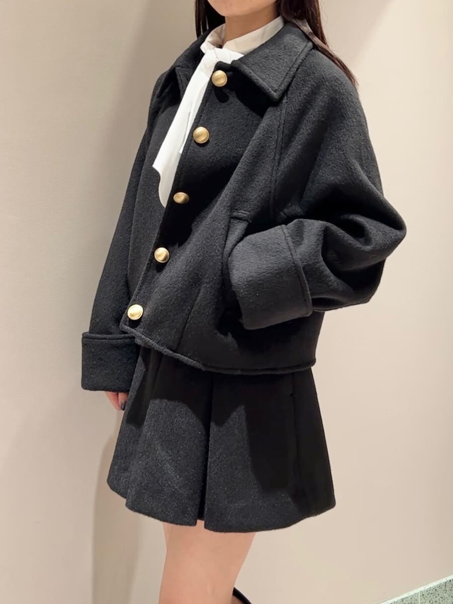 ブラック系のブルゾン、グレー系のニット/セーター、ブラック系のスカートを着用したレディースの秋コーディネートの4枚目の写真