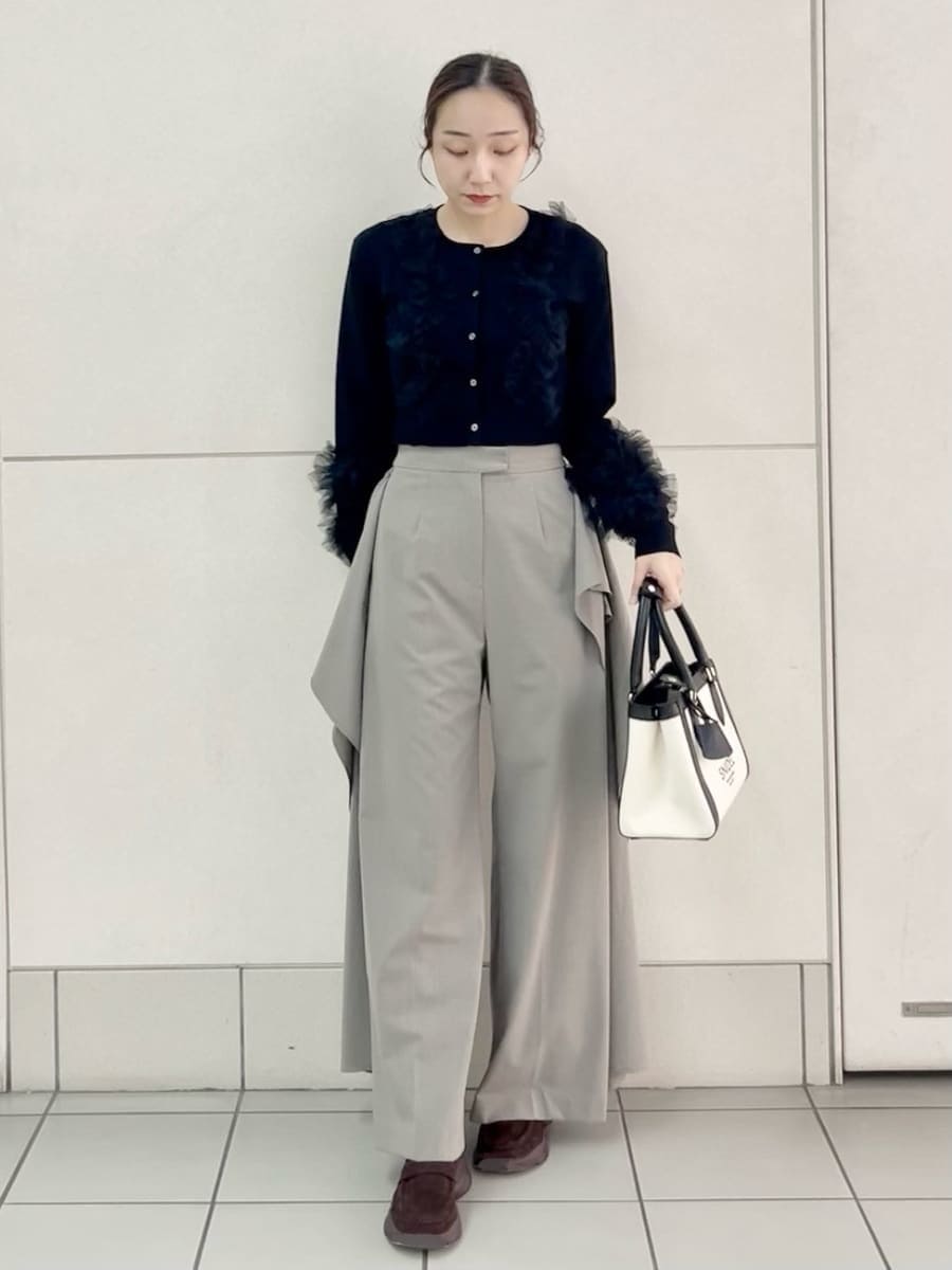ベージュ系のその他パンツ、ブラック系のカーディガン/ボレロ、ホワイト系のハンドバッグを着用したレディースの春コーディネートの2枚目の写真
