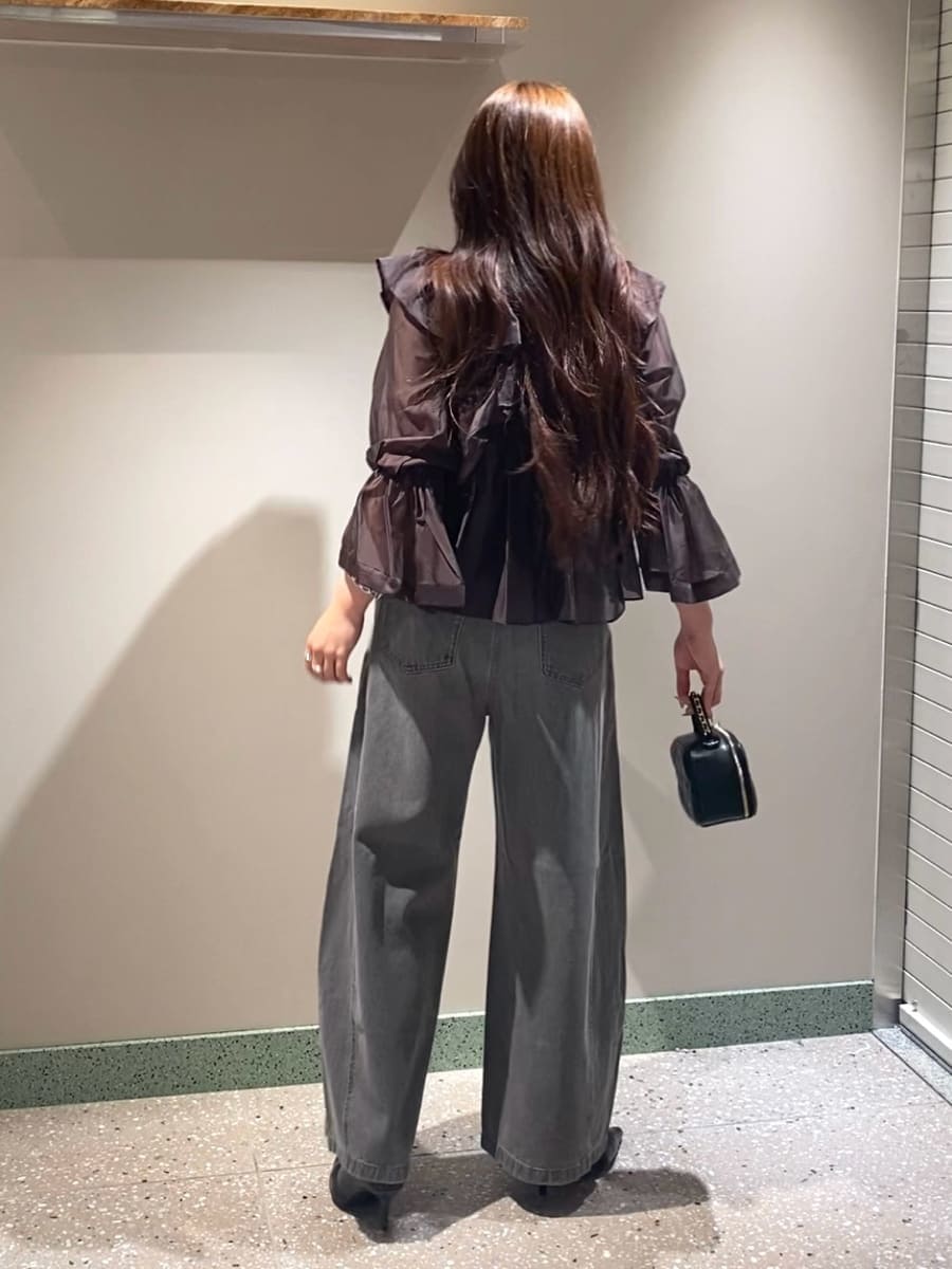グレー系のデニムパンツ、ブラウン系のシャツ/ブラウス、ブラック系のブーツを着用したレディースの秋コーディネートの3枚目の写真