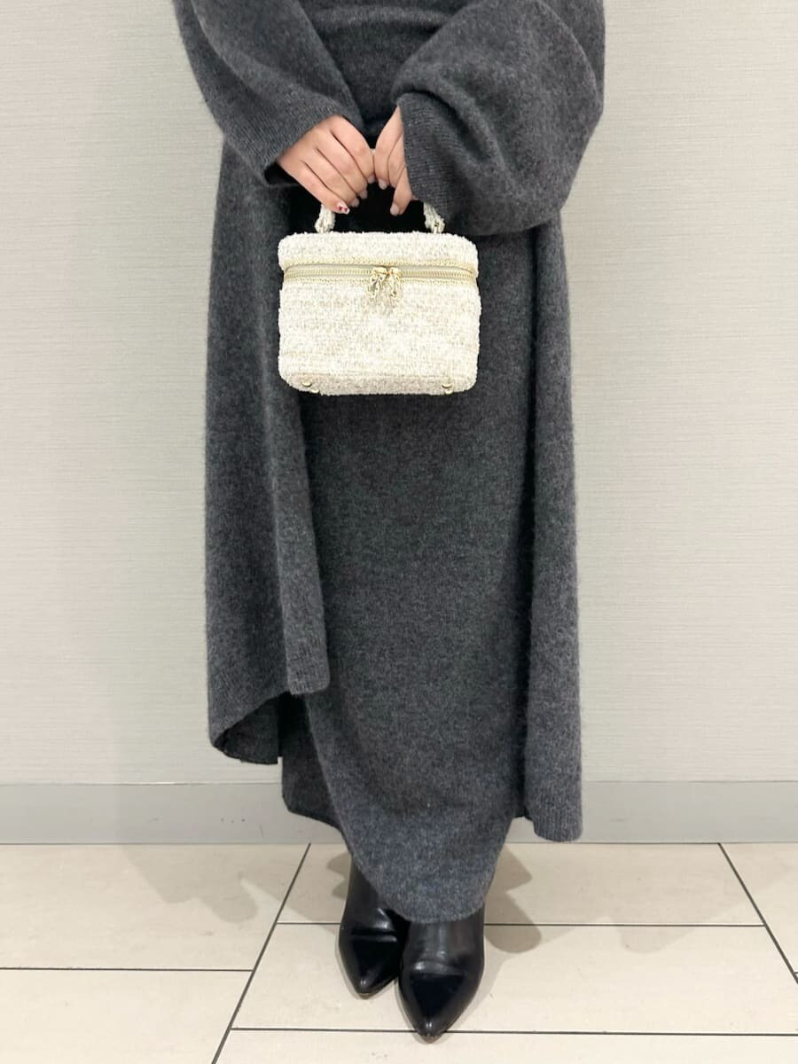 グレー系のチェスターコート、グレー系のワンピースを着用したレディースの冬コーディネートの5枚目の写真
