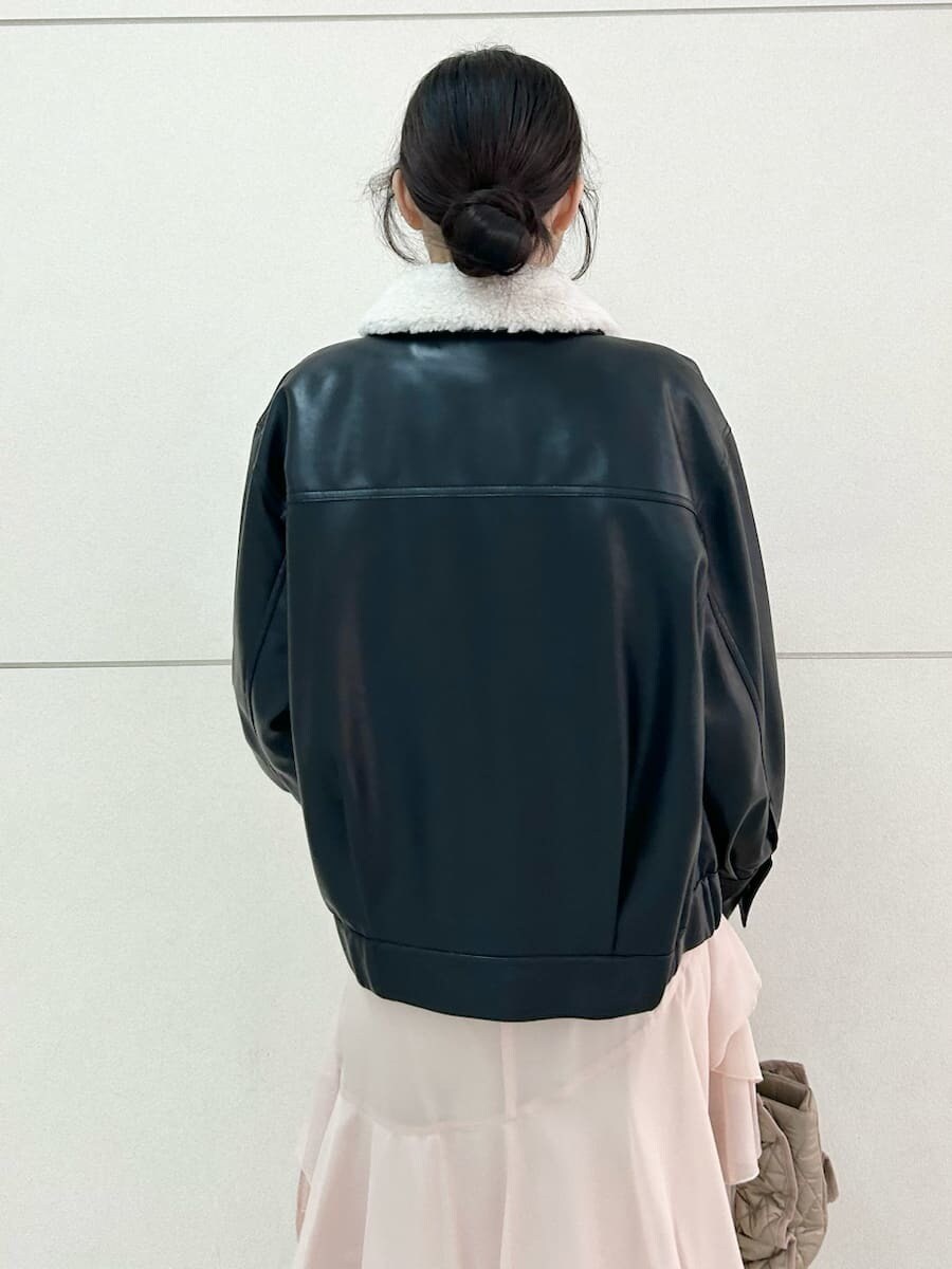 ベージュ系のハンドバッグ、ブラック系のブルゾン、ピンク系のワンピースを着用したレディースの冬コーディネートの7枚目の写真