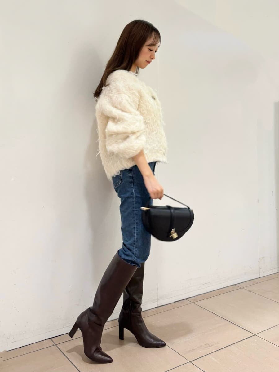 ホワイト系のカーディガン/ボレロ、ブルー系のデニムパンツ、ブラウン系のブーツを着用したレディースの秋コーディネートの2枚目の写真