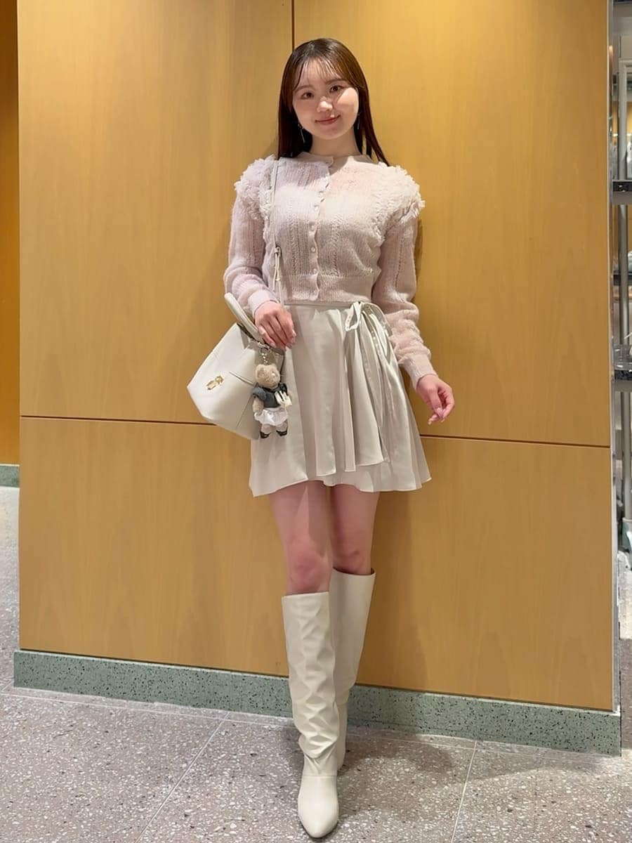 ホワイト系のその他パンツ、ピンク系のカーディガン/ボレロ、ホワイト系のブーツを着用したレディースの冬コーディネートの2枚目の写真