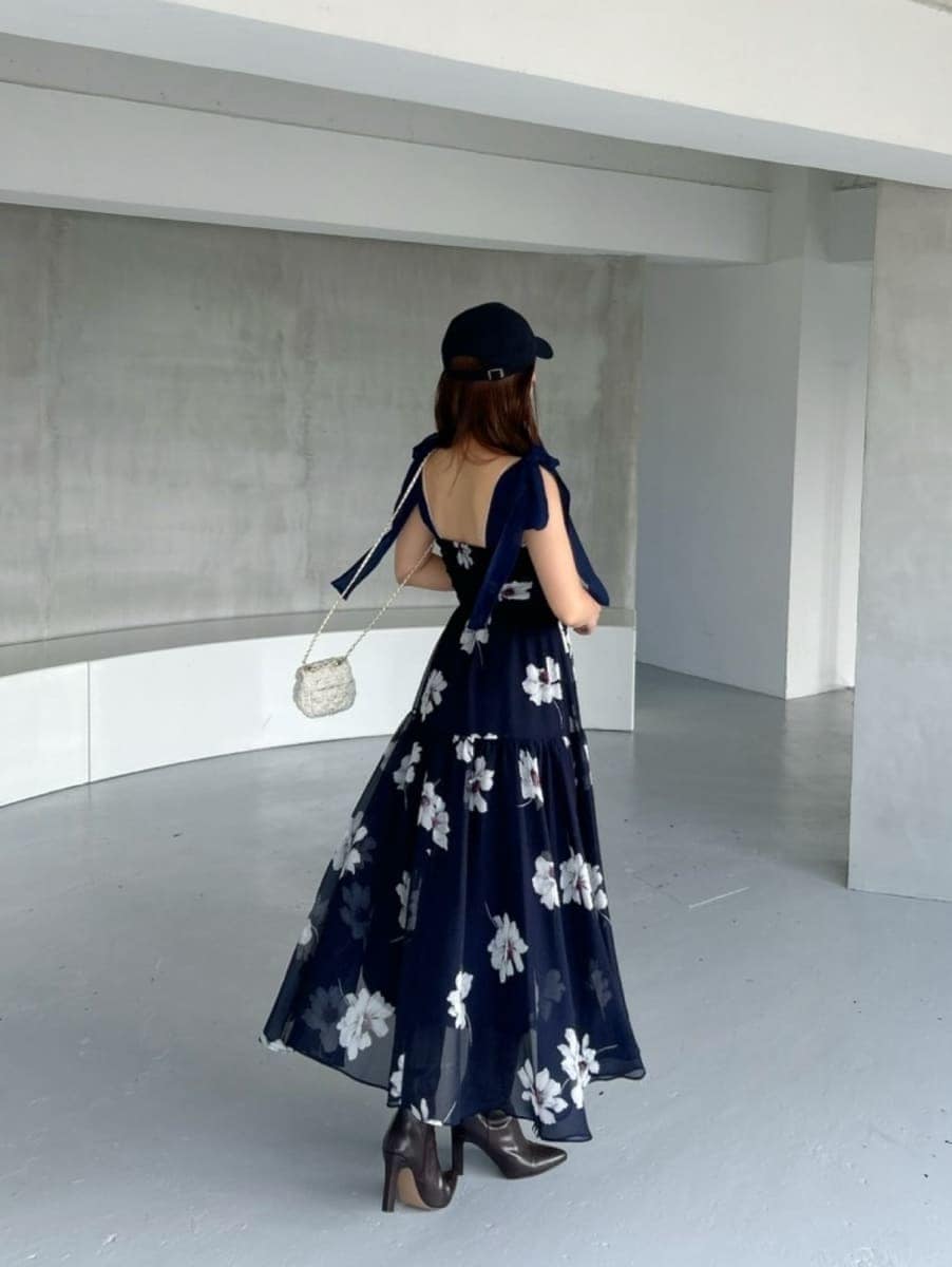 ブルー系のワンピース、ホワイト系のショルダーバッグ、ブラック系のブーツを着用したレディースの夏コーディネートの2枚目の写真