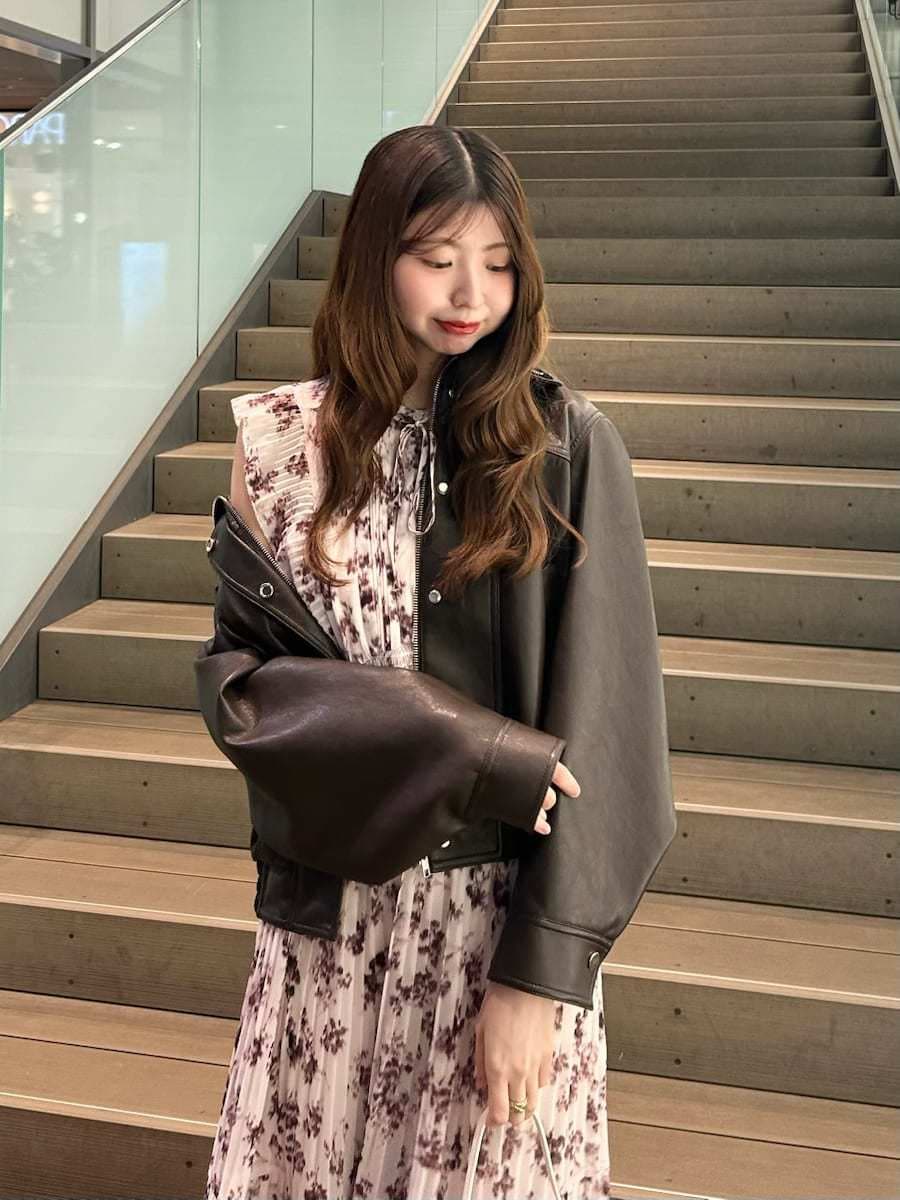 ピンク系のワンピース、ブラウン系のブルゾン、ホワイト系のハンドバッグを着用したレディースの春コーディネートの3枚目の写真