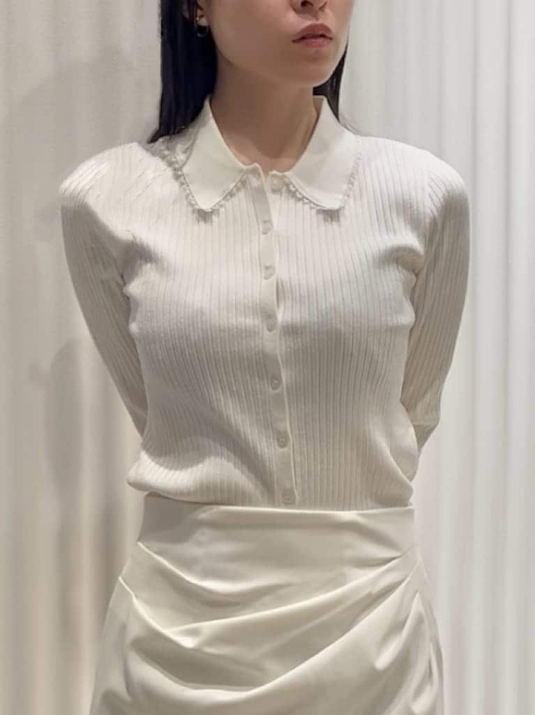 ベージュ系のトレンチコート、ホワイト系のスカート、ブラウン系のパンプスを着用したレディースの冬コーディネートの7枚目の写真