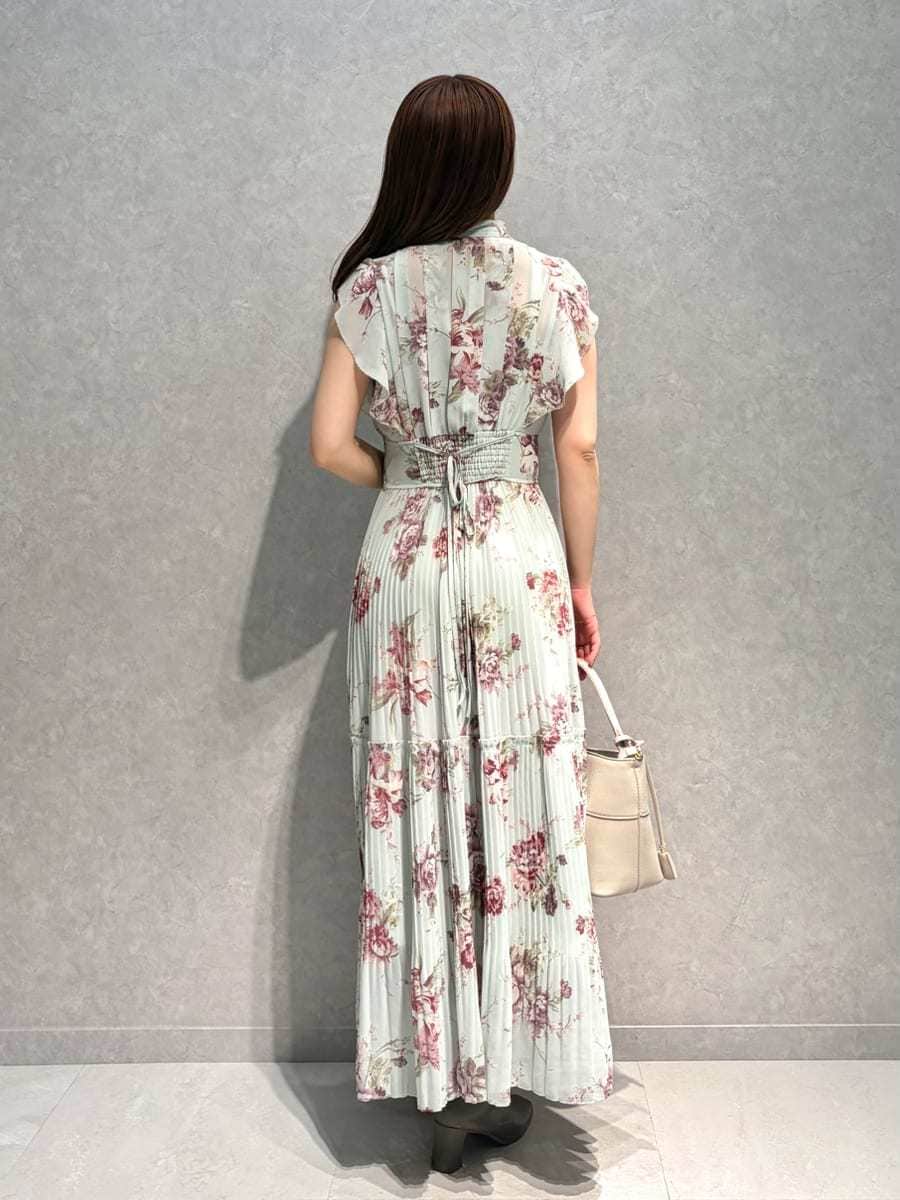 ホワイト系のテーラードジャケット、グリーン系のワンピース、ベージュ系のハンドバッグを着用したレディースの春コーディネートの6枚目の写真