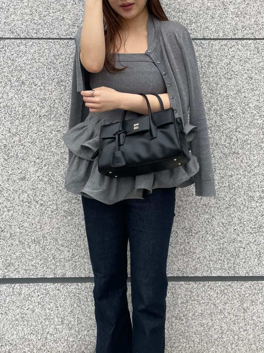 シルバー系のニット/セーター、シルバー系のカーディガン/ボレロ、ブルー系のデニムパンツを着用したレディースの春コーディネートの4枚目の写真