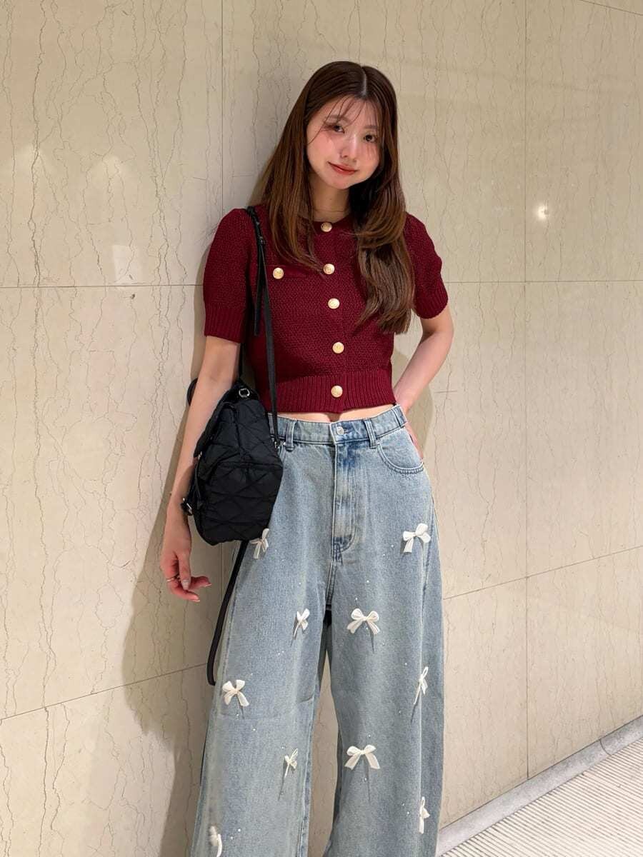 ブルー系のその他パンツ、レッド系のカーディガン/ボレロ、ブラック系のバックパック/リュックを着用したレディースの夏コーディネートの2枚目の写真