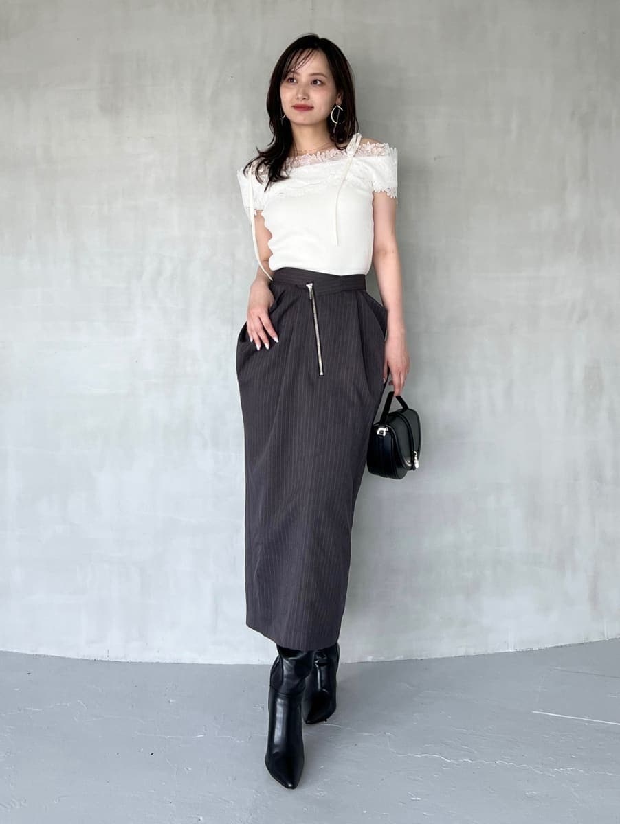 ホワイト系のニット/セーター、グレー系のスカート、ブラック系のブーツを着用したレディースの秋コーディネートの3枚目の写真