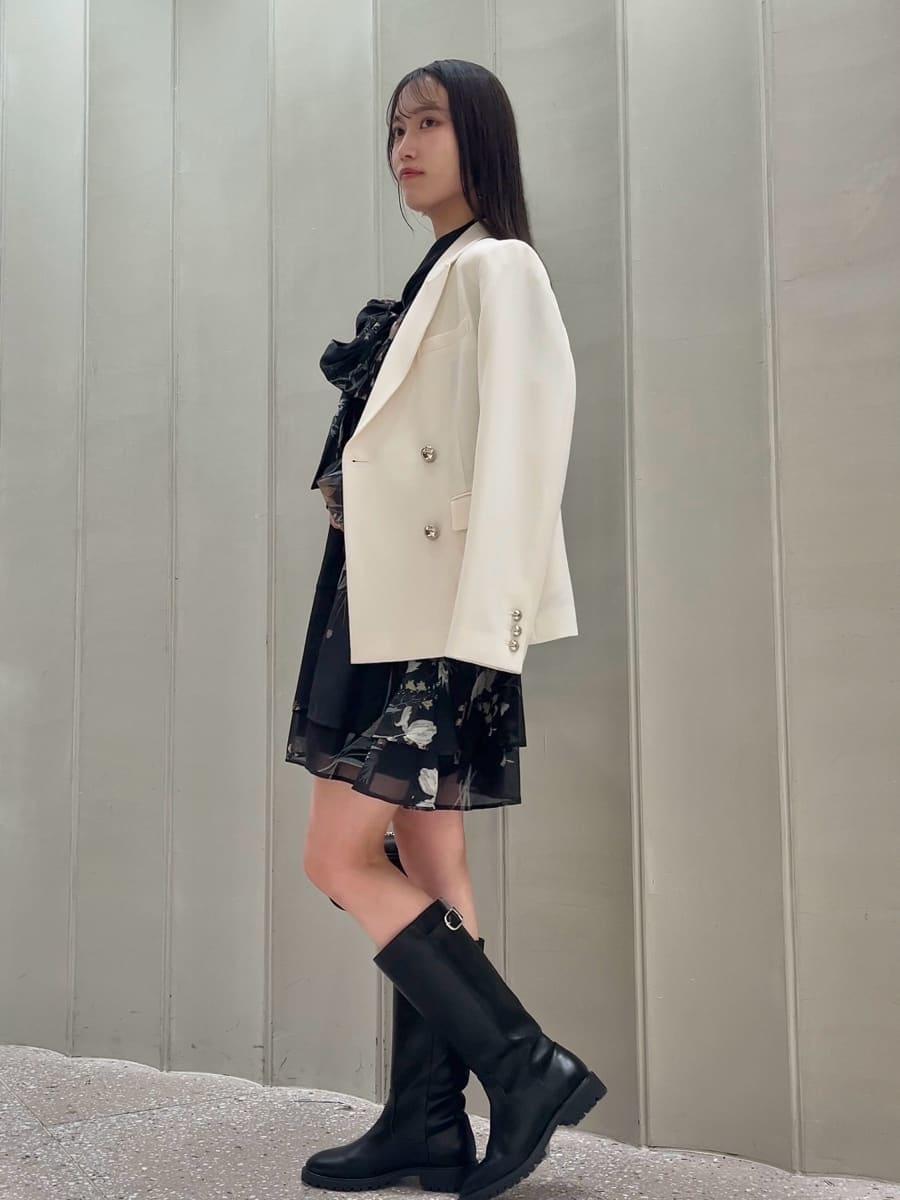 ホワイト系のテーラードジャケット、ブルー系のワンピース、ブラック系のショルダーバッグを着用したレディースの冬コーディネートの2枚目の写真