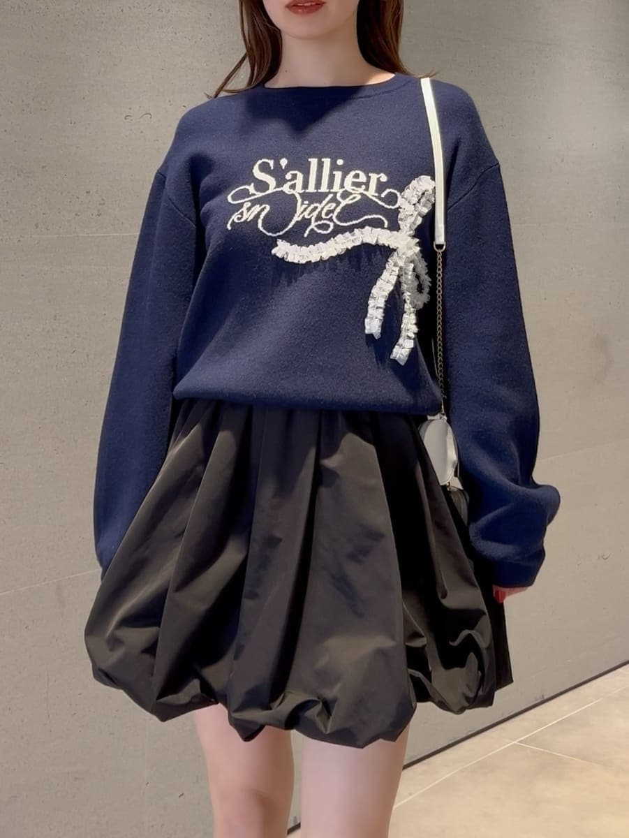 ブラック系のその他パンツ、ブルー系のニット/セーター、ホワイト系のショルダーバッグを着用したレディースの冬コーディネートの2枚目の写真