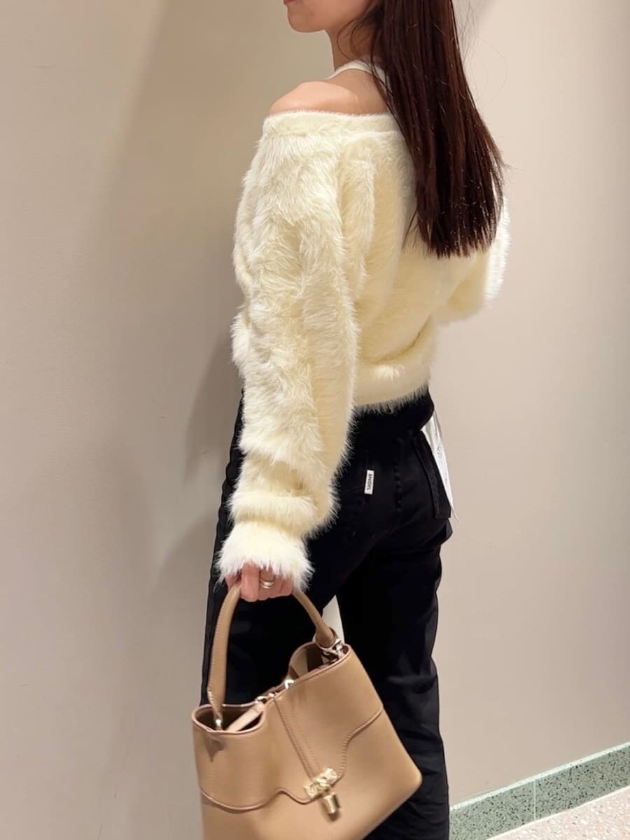 イエロー系のニット/セーター、ブラック系のその他パンツ、イエロー系のハンドバッグを着用したレディースの秋コーディネートの5枚目の写真