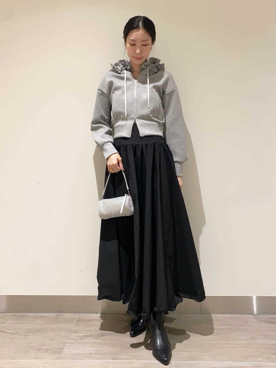 ブラック系のパンプス、グレー系のパーカー、ブラック系のスカートを着用したレディースの冬コーディネートの4枚目の写真