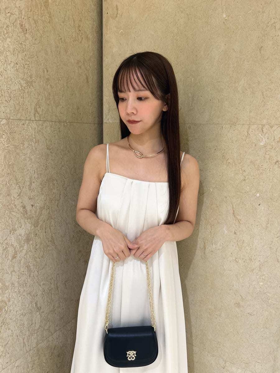 ホワイト系のサンダル、ブラック系のショルダーバッグ、ホワイト系のワンピースを着用したレディースの夏コーディネートの2枚目の写真