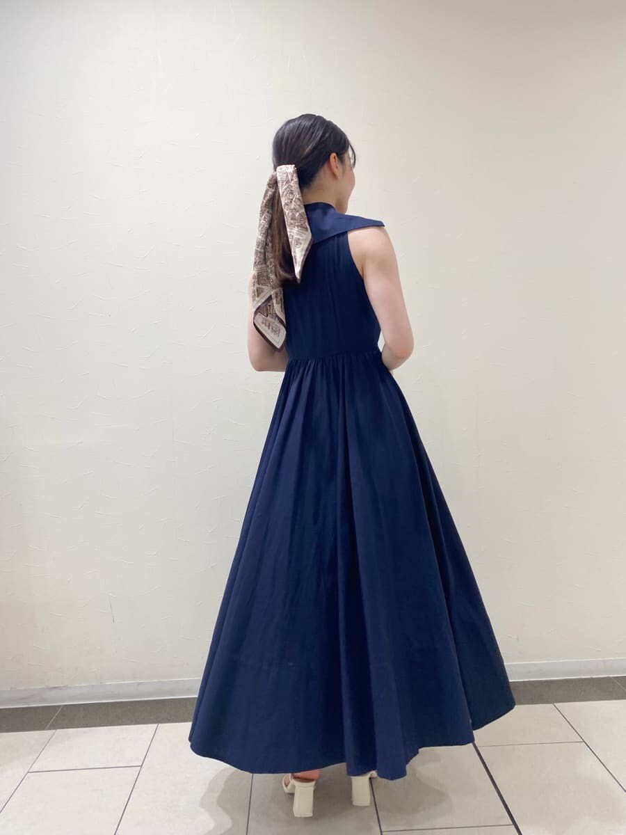 ブルー系のワンピース、ベージュ系のハンドバッグ、ホワイト系のパンプスを着用したレディースの夏コーディネートの4枚目の写真