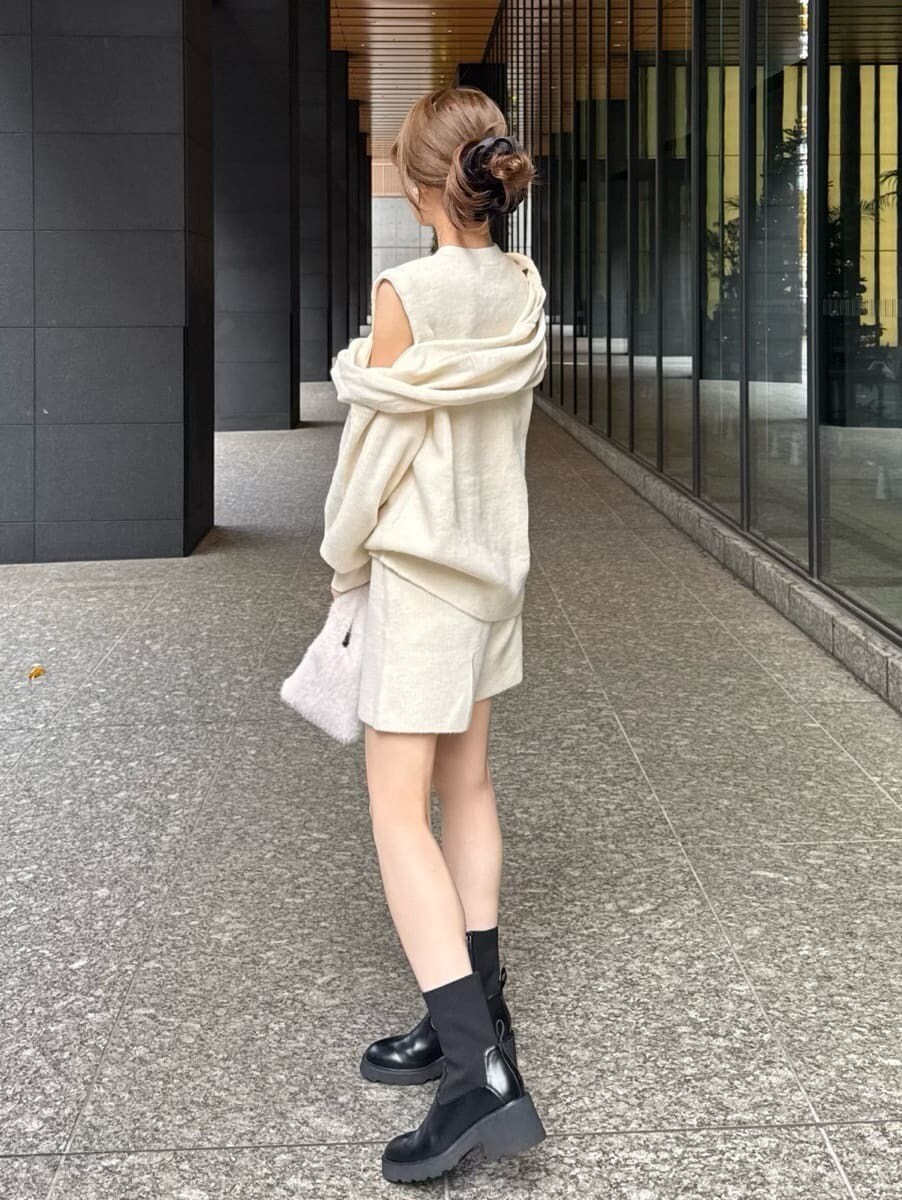 ホワイト系のその他パンツ、ホワイト系のニット/セーター、ホワイト系のハンドバッグを着用したレディースの冬コーディネートの4枚目の写真