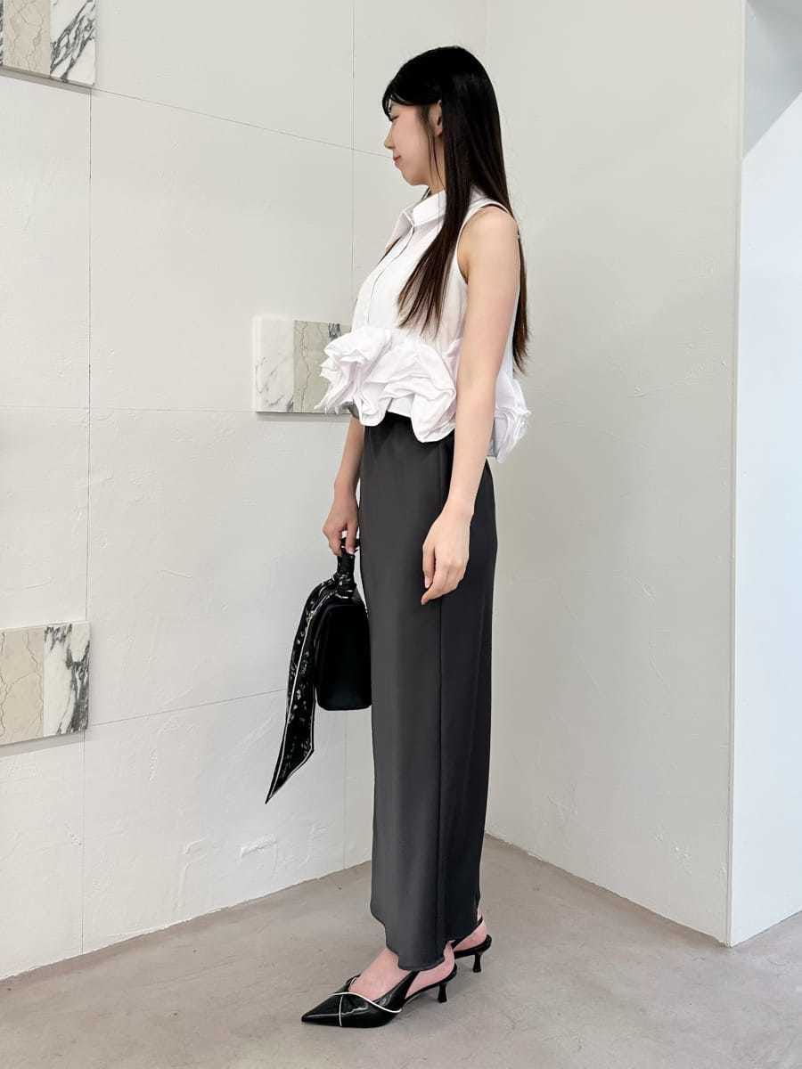 ブラック系のパンプス、ブラック系のハンドバッグ、グレー系のスカートを着用したレディースの夏コーディネートの2枚目の写真