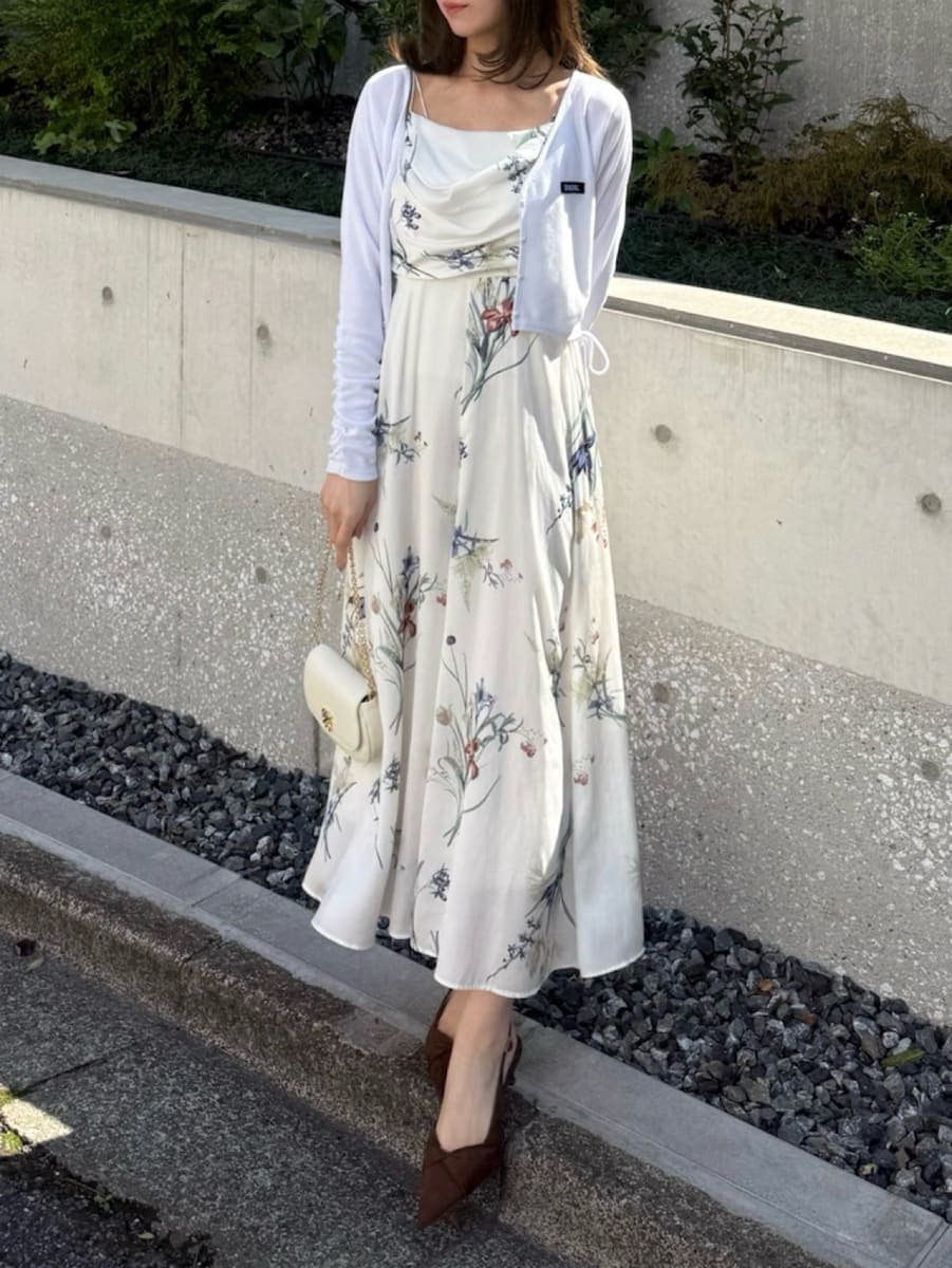 ホワイト系のワンピース、ブラウン系のパンプス、ホワイト系のショルダーバッグを着用したレディースの春コーディネートの2枚目の写真