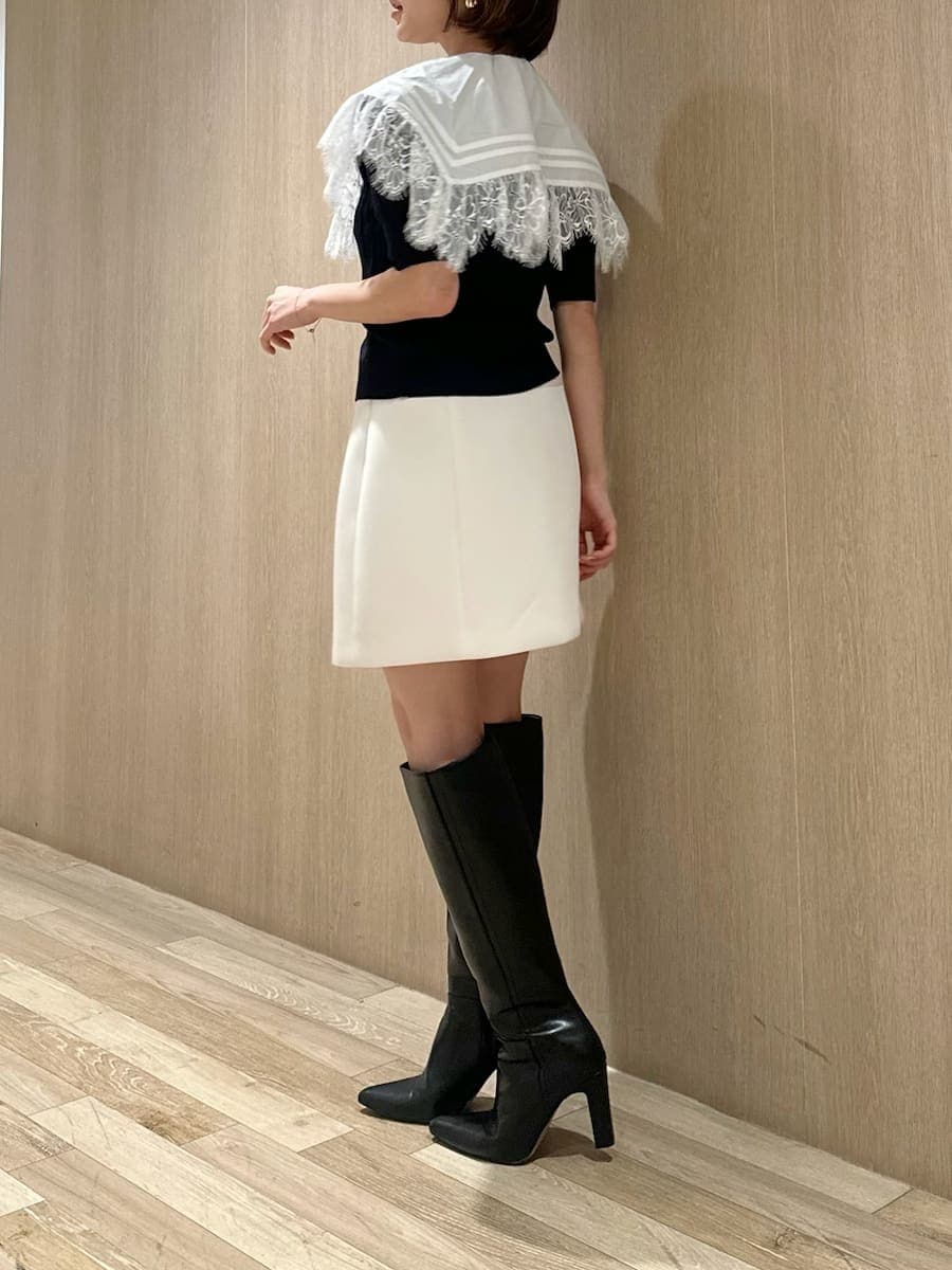 ブラック系のブーツ、ホワイト系のスカート、ブルー系のカーディガン/ボレロを着用したレディースの春コーディネートの5枚目の写真