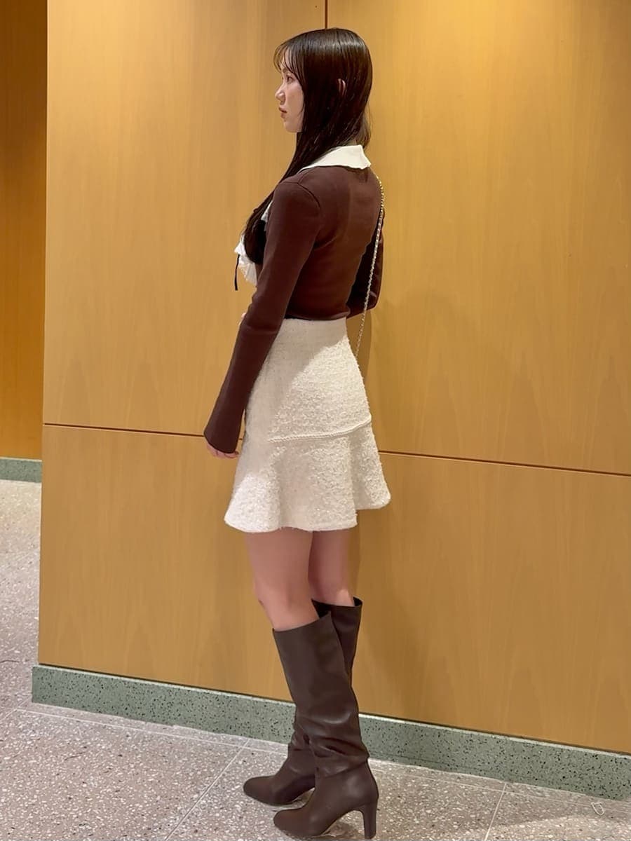 ホワイト系のショルダーバッグ、ブラウン系のニット/セーター、ホワイト系のスカートを着用したレディースの冬コーディネートの3枚目の写真