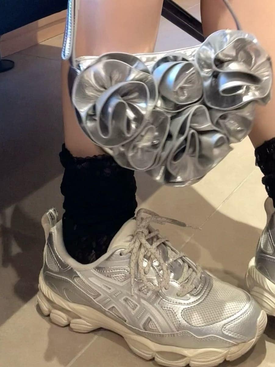 ブラック系のドレス、シルバー系のスニーカーを着用したレディースの冬コーディネートの6枚目の写真