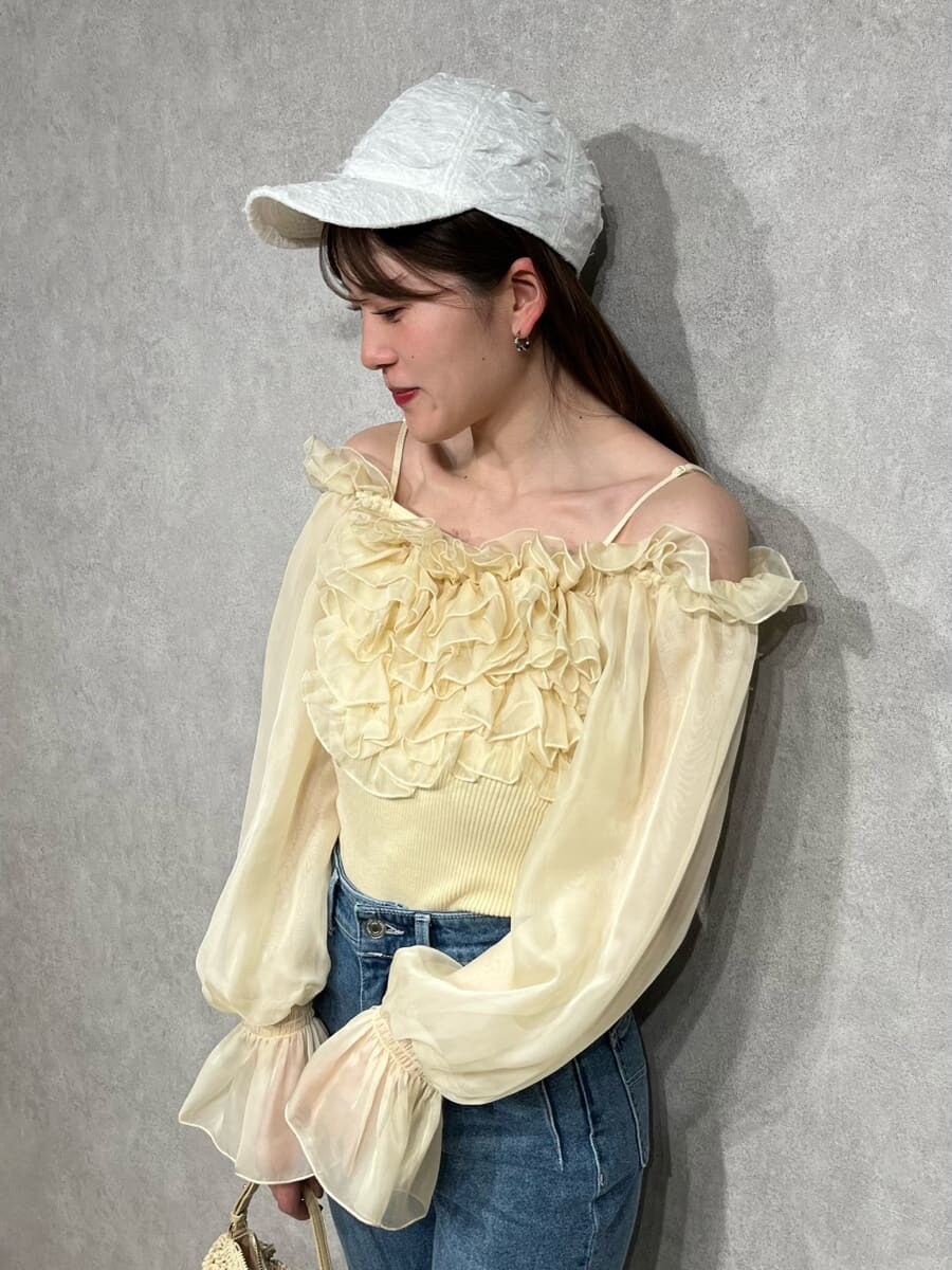 ブルー系のその他パンツ、イエロー系のニット/セーター、ホワイト系のキャップを着用したレディースの冬コーディネートの4枚目の写真