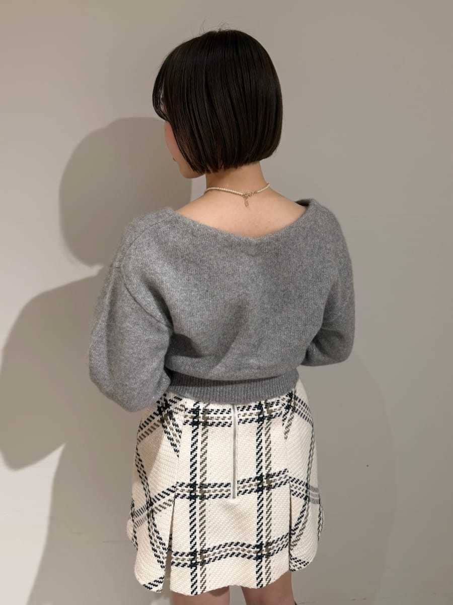 ホワイト系のスカート、グレー系のカーディガン/ボレロ、ゴールド系のキーケース/キーアクセサリーを着用したレディースの冬コーディネートの10枚目の写真