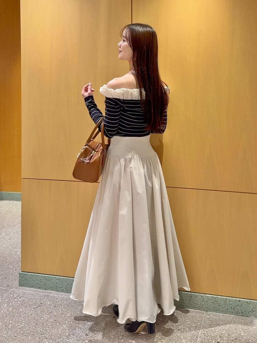 ブラック系のブーツ、ホワイト系のスカート、その他のニット/セーターを着用したレディースの冬コーディネートの3枚目の写真