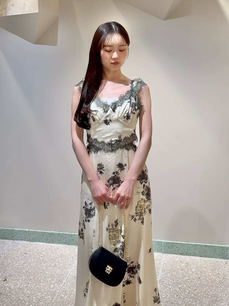 イエロー系のワンピース、ブラック系のショルダーバッグ、シルバー系のピアス（両耳用）を着用したレディースの春コーディネートの3枚目の写真